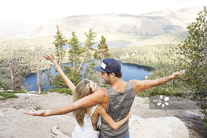 幸福的夫妇张开双臂站在森林山上的背影图片素材