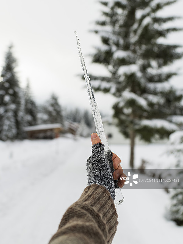 冬季，女子戴露指手套持冰柱手部特写图片素材