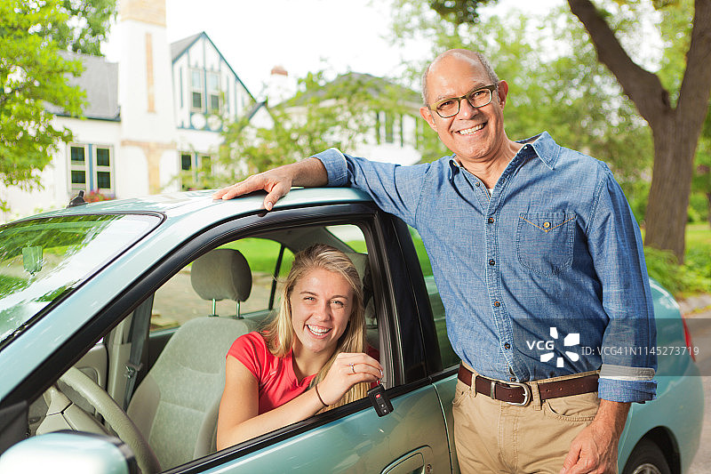 和她的新车在一起的年轻少女学生司机图片素材