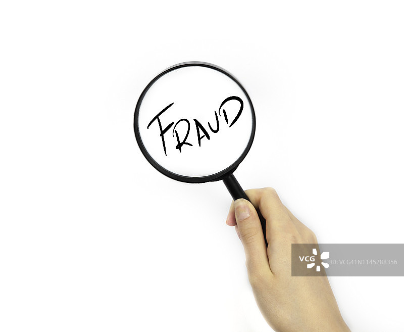 用放大镜观察“欺诈”字样图片素材
