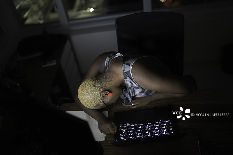 疲惫的女商人趴在办公桌上小憩图片素材