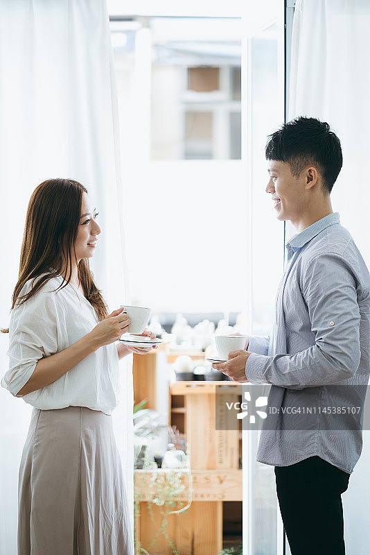 情侣在家中窗边喝咖啡聊天图片素材