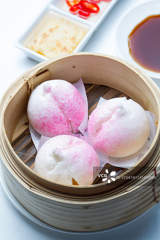 竹碗里色彩鲜艳美味的中式包子图片素材