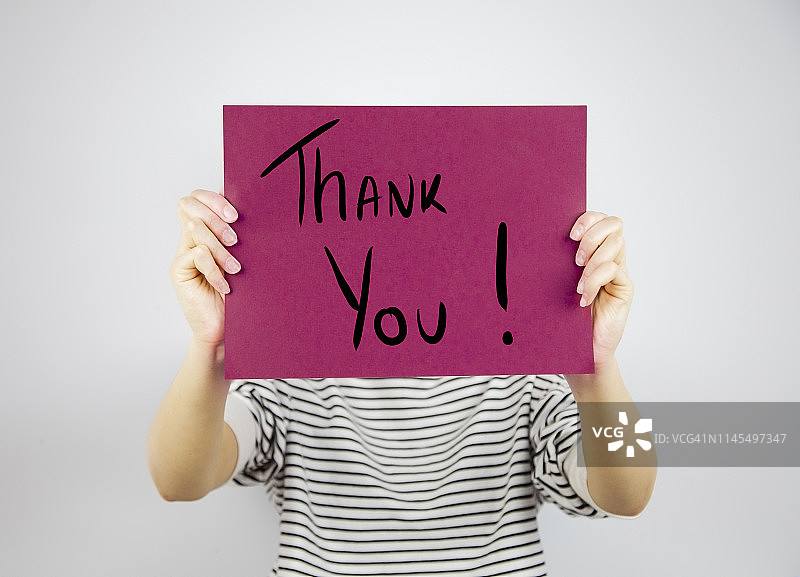 展示写有“谢谢”字样的纸张的女人图片素材
