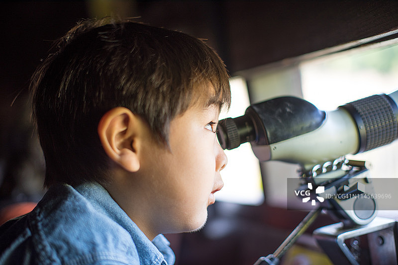 男孩用双筒望远镜观察图片素材