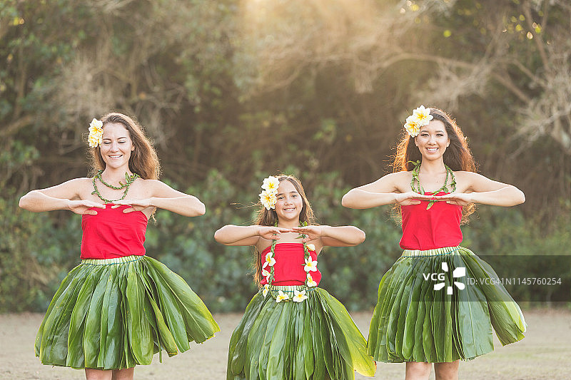 三个跳草裙舞的舞者在户外表演图片素材