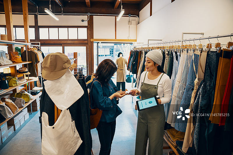 零售店员在平板电脑上收取移动信用卡付款图片素材