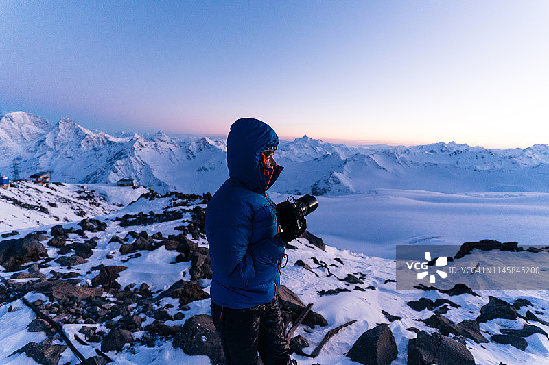 登山滑雪者在日出时于山顶拍照图片素材