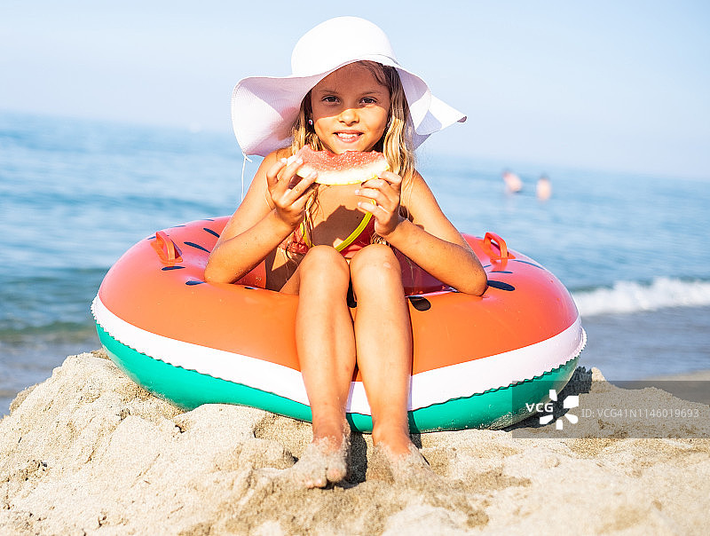 在海滩上吃西瓜的漂亮女孩图片素材