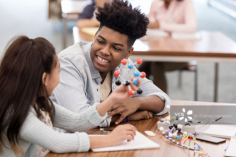 亚裔女孩向导师展示她的分子模型图片素材