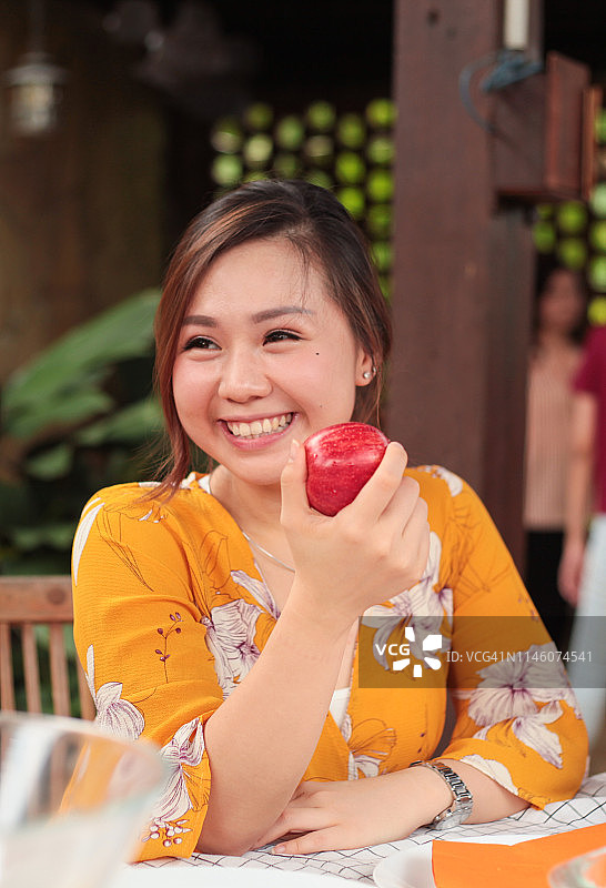 微笑吃苹果的年轻女人图片素材