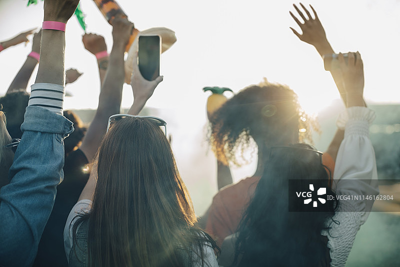 女士在音乐节上与朋友们一起使用智能手机图片素材