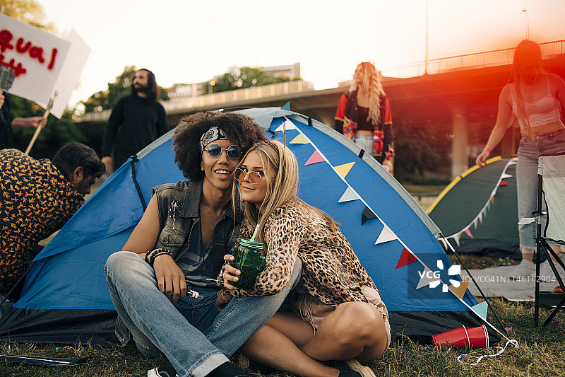 音乐活动中坐在草坪帐篷外微笑的朋友们的肖像图片素材