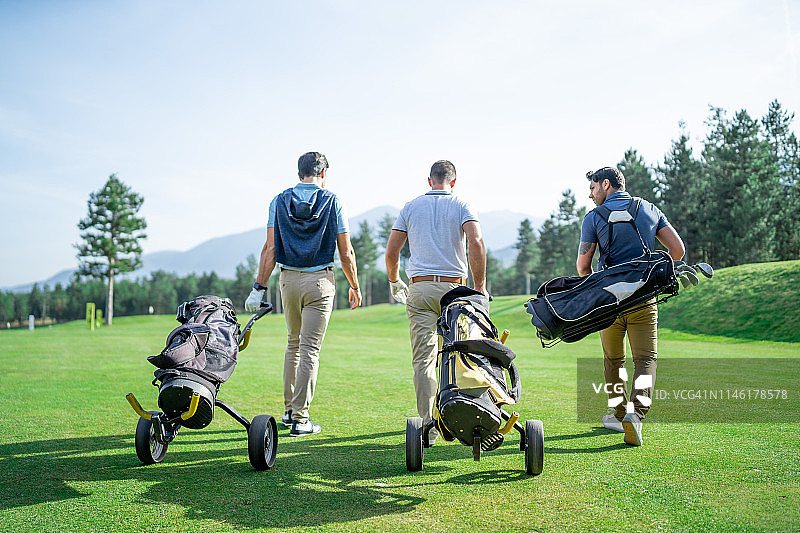 朋友们在阳光明媚的日子里打高尔夫图片素材