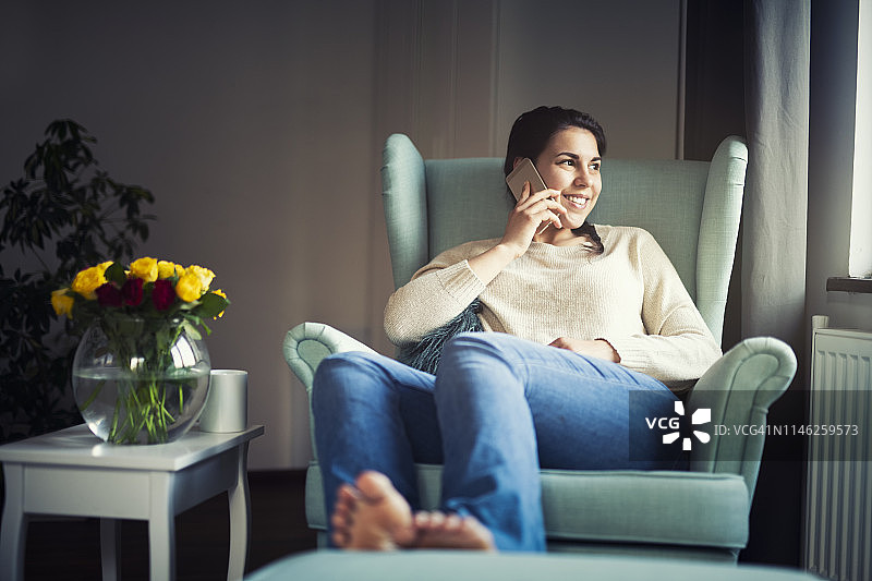 微笑的女人在家打电话图片素材