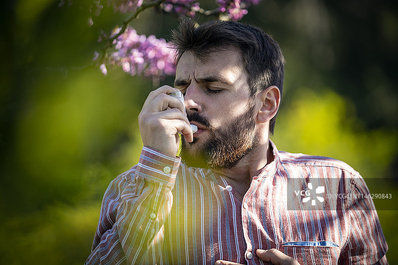 男人在户外使用哮喘吸入器图片素材