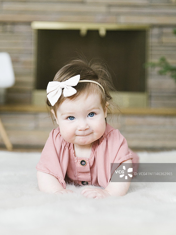 躺在地毯上戴蝴蝶结发带的女婴图片素材