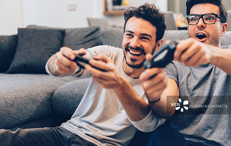 兴奋的朋友们玩电子游戏图片素材