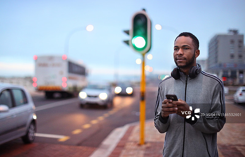 一个非洲男人在公共道路旁使用手机图片素材