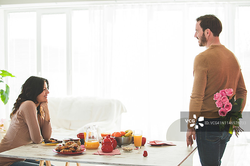 男人在家给妻子送玫瑰花束图片素材