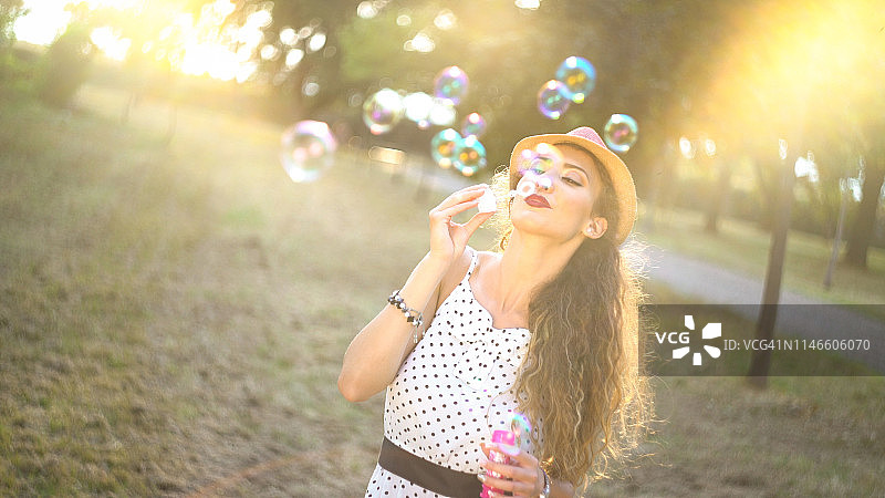 在户外吹泡泡的年轻女人图片素材