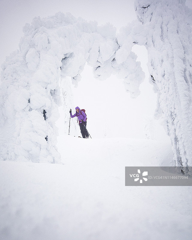 女子在结满冰的树下滑雪图片素材