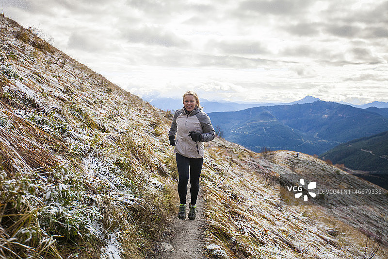 在阿尔卑斯草甸中慢跑的年轻女人图片素材
