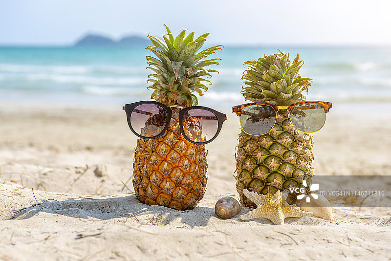 热带海滩背景上的太阳镜菠萝图片素材
