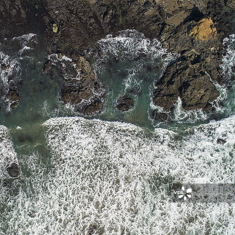 美国加利福尼亚州太平洋沿岸悬崖和岩石周围的冲浪鸟瞰图图片素材