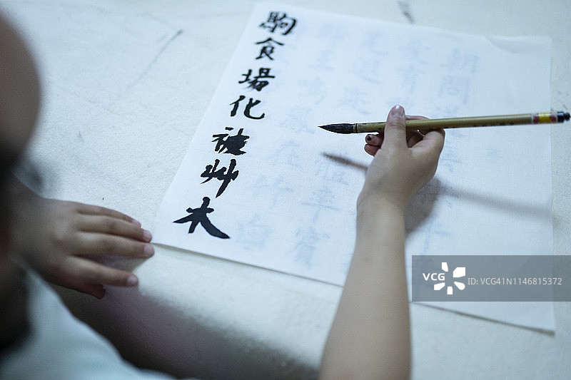 手持毛笔书写书法特写图片素材