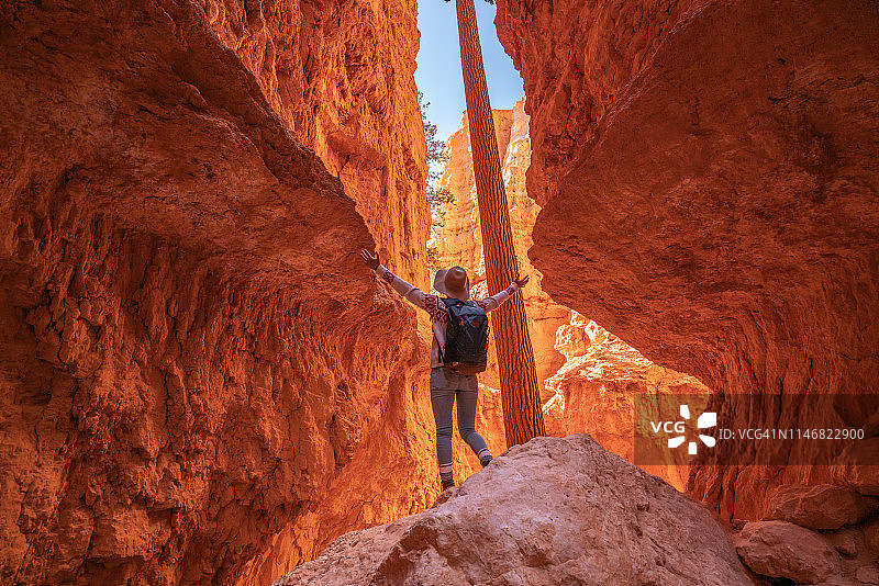 女孩在美国旅行参观国家公园，站在布莱斯峡谷内张开双臂图片素材