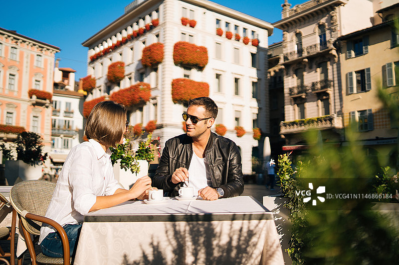 情侣坐在城镇广场的咖啡馆户外图片素材