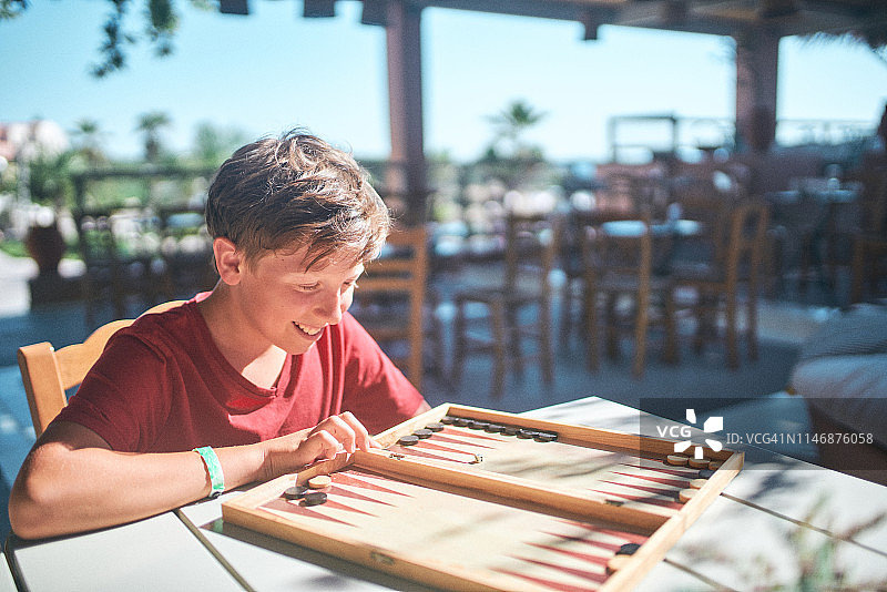 青少年男孩在度假时玩双陆棋图片素材