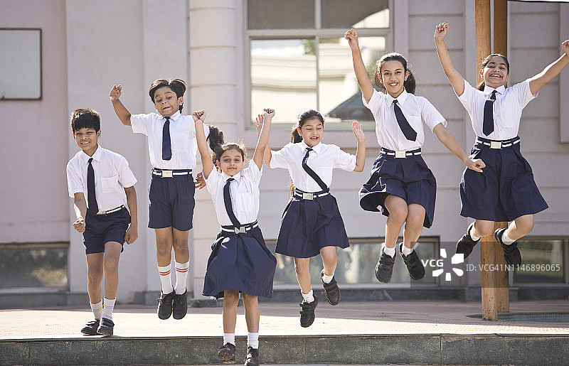 小学生在校园里跳跃欢庆图片素材