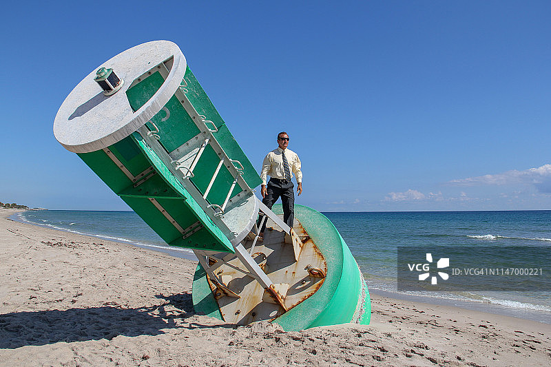 站在搁浅的浮标航道标志上的商人图片素材
