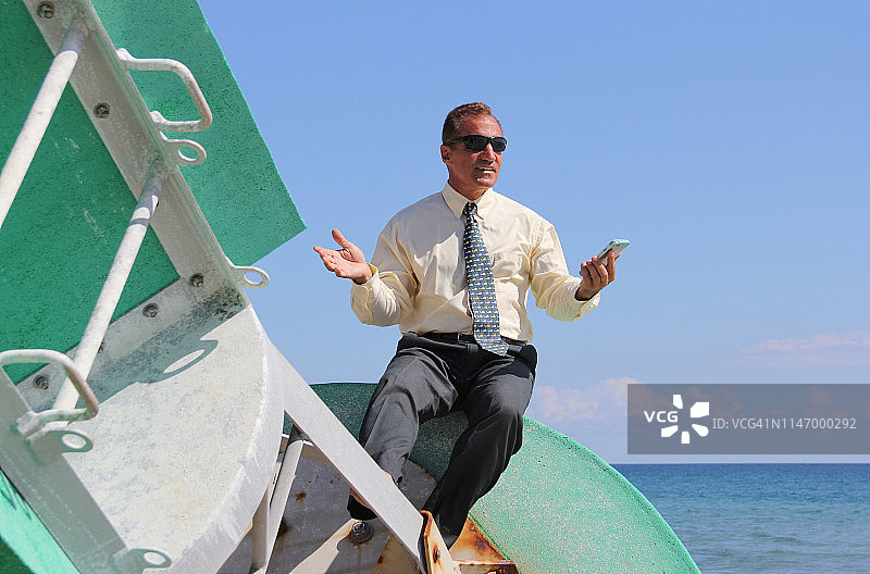 在海上浮标上使用手机的商人图片素材