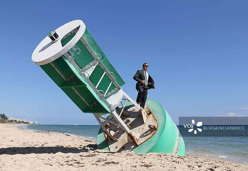 站在海滩浮标航道标志上的商人图片素材