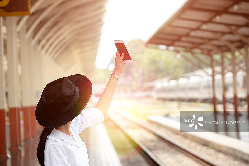 女游客用智能手机自拍图片素材
