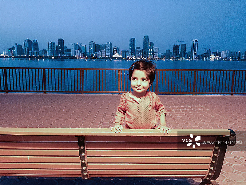站在长椅上的幼儿女孩肖像图片素材