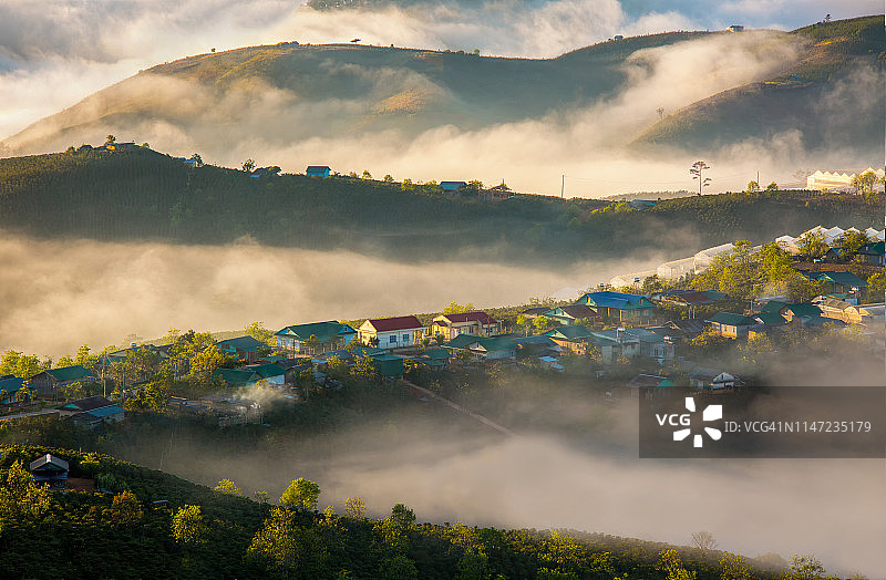 雾气和阳光下的梦幻村庄图片素材