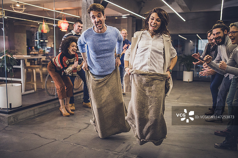 在休闲办公室玩袋子赛跑的创业者图片素材