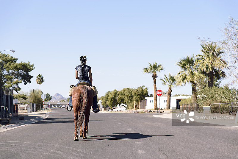 女人在城市街道上骑马图片素材