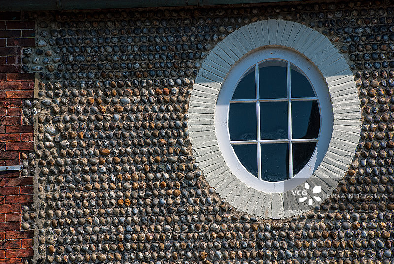 卵石墙上的椭圆窗户图片素材