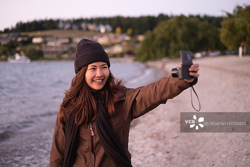 年轻的亚洲女人在海滩上录制视频博客图片素材