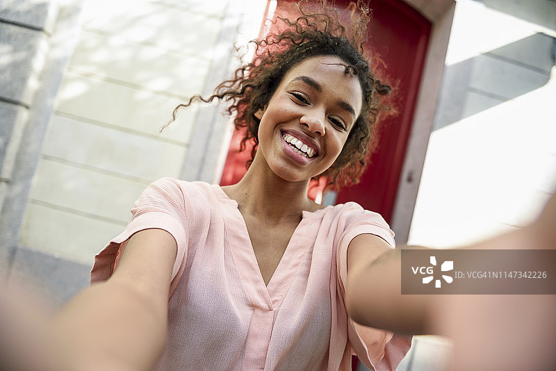 在城市里自拍的快乐年轻女子图片素材