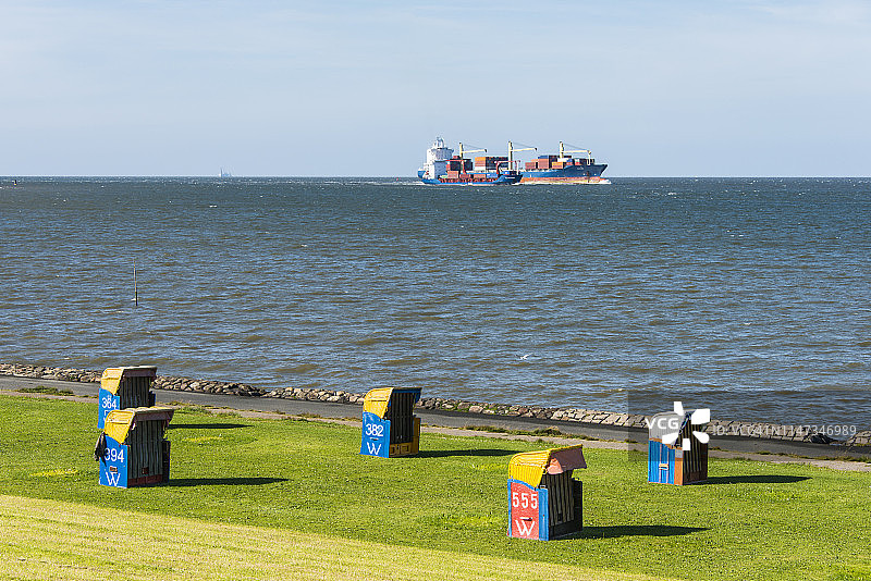 德国库克斯哈芬：巨型货船经过带有沙滩椅的海滩图片素材