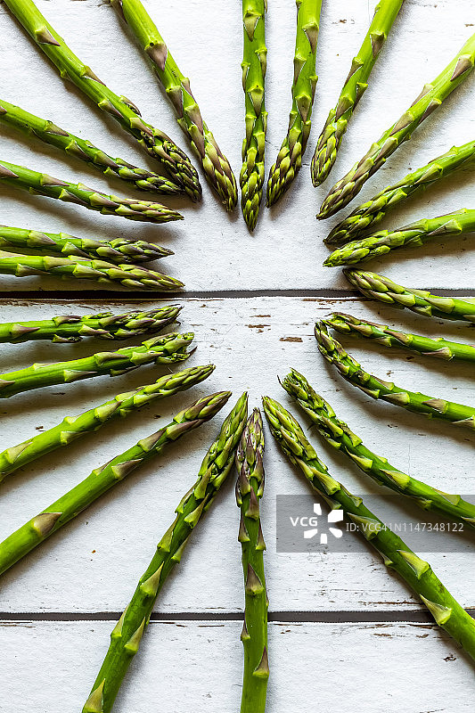 木板上用绿芦笋摆成的心形图片素材
