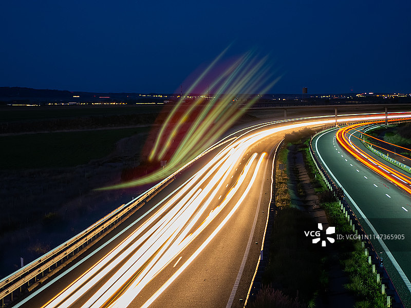 黄昏弯道行驶的车辆灯光轨迹图片素材