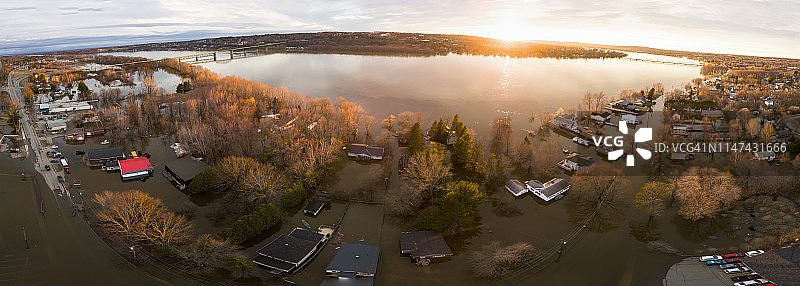 加拿大新不伦瑞克省弗雷德里克顿市，日落时分巴克尔斯角圣约翰河被洪水淹没的无人机全景图片素材
