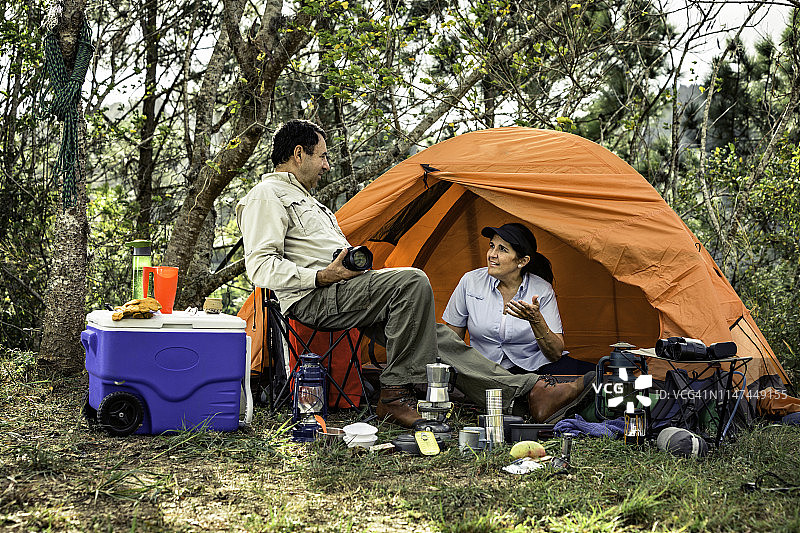 快乐的中年西班牙裔夫妇在野外露营图片素材